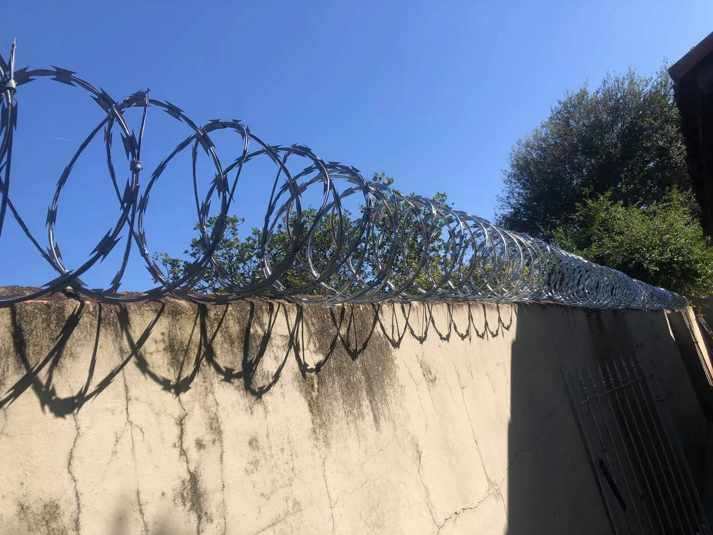 Concertina instalada ao longo de um muro, vista em perspectiva